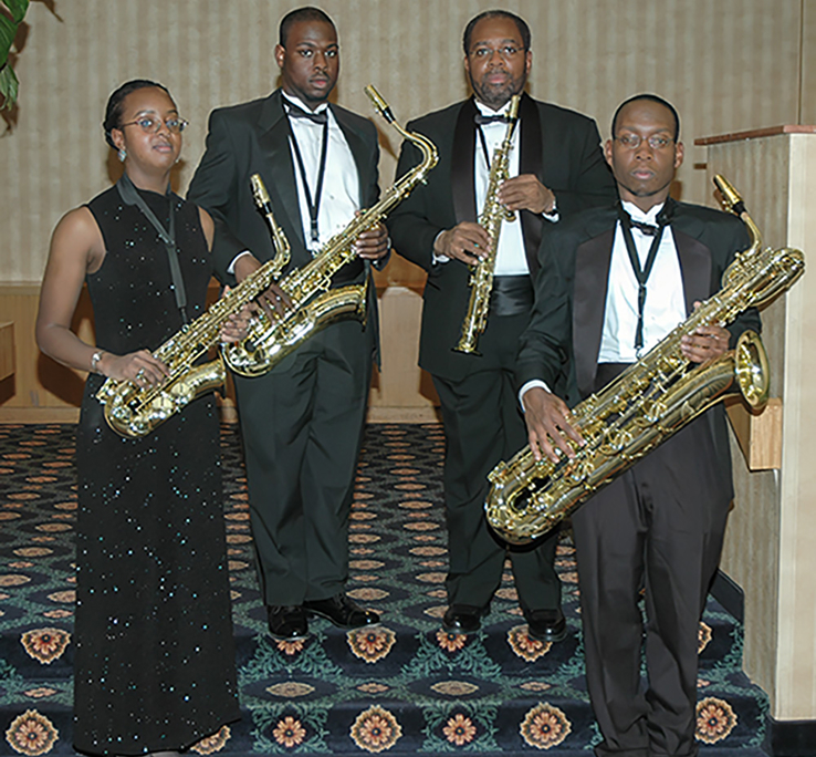 Photo of a brass quartet posing with their instruments